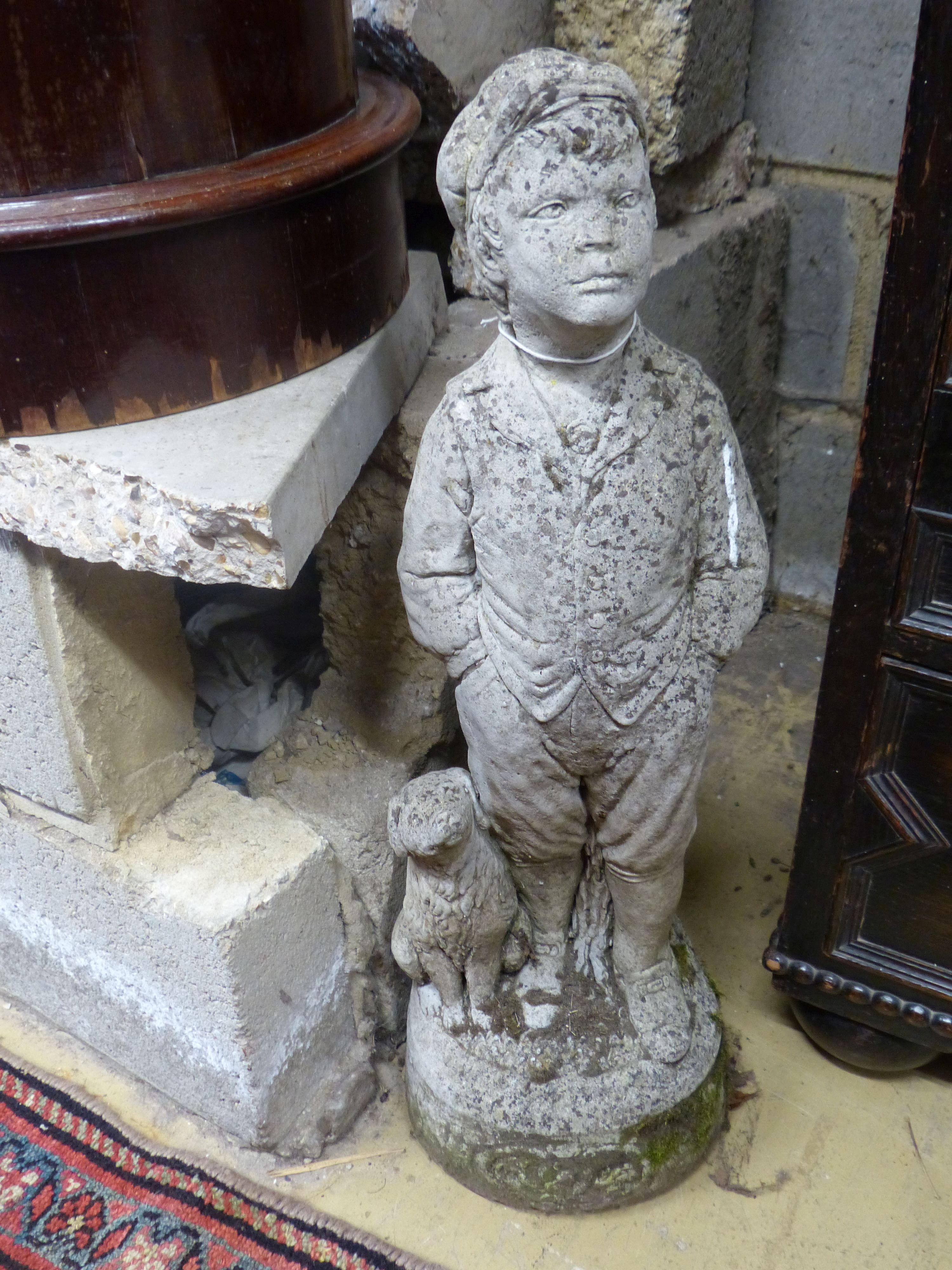 A reconstituted stone garden ornament of a boy with dog, height 69cm